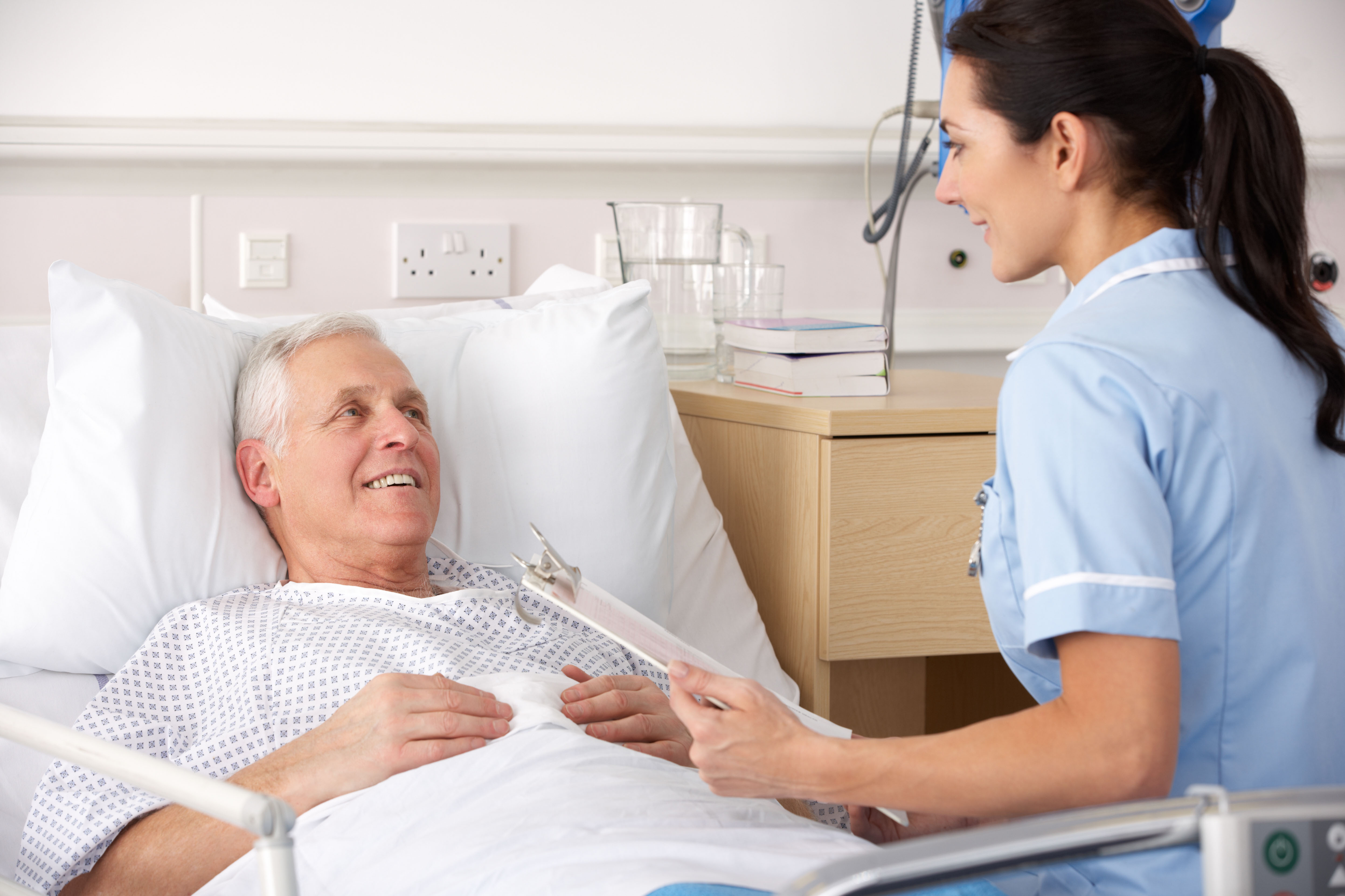 Nurse with senior male patient in bed Maidstone and Tunbridge Wells NHS Trust